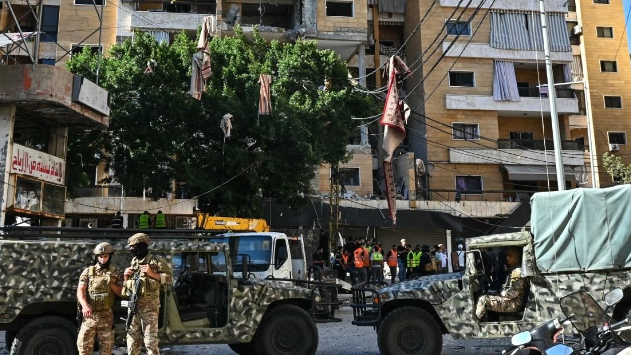 Soldados libaneses montam guarda enquanto equipes de resgate inspecionam os dano